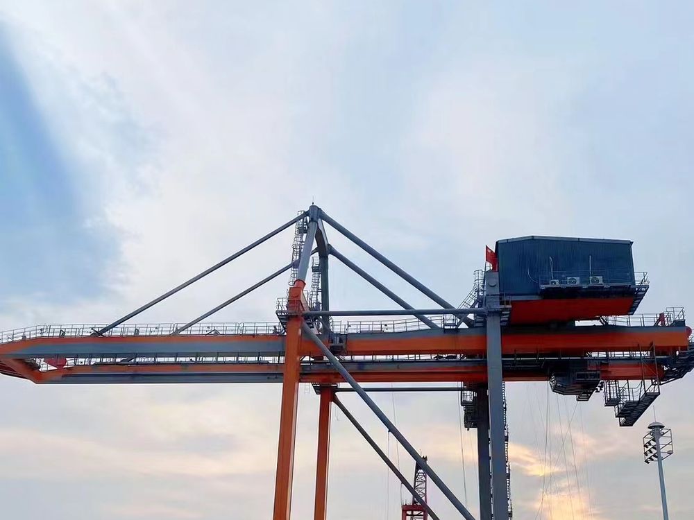 Rail-mounted gantry crane working a yard at sunset
