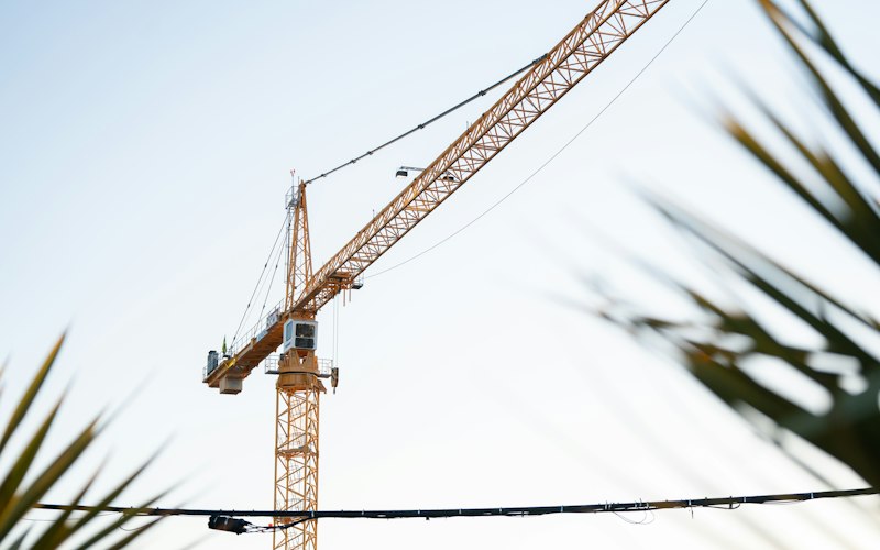 Yellow jib-type crane against the sky
